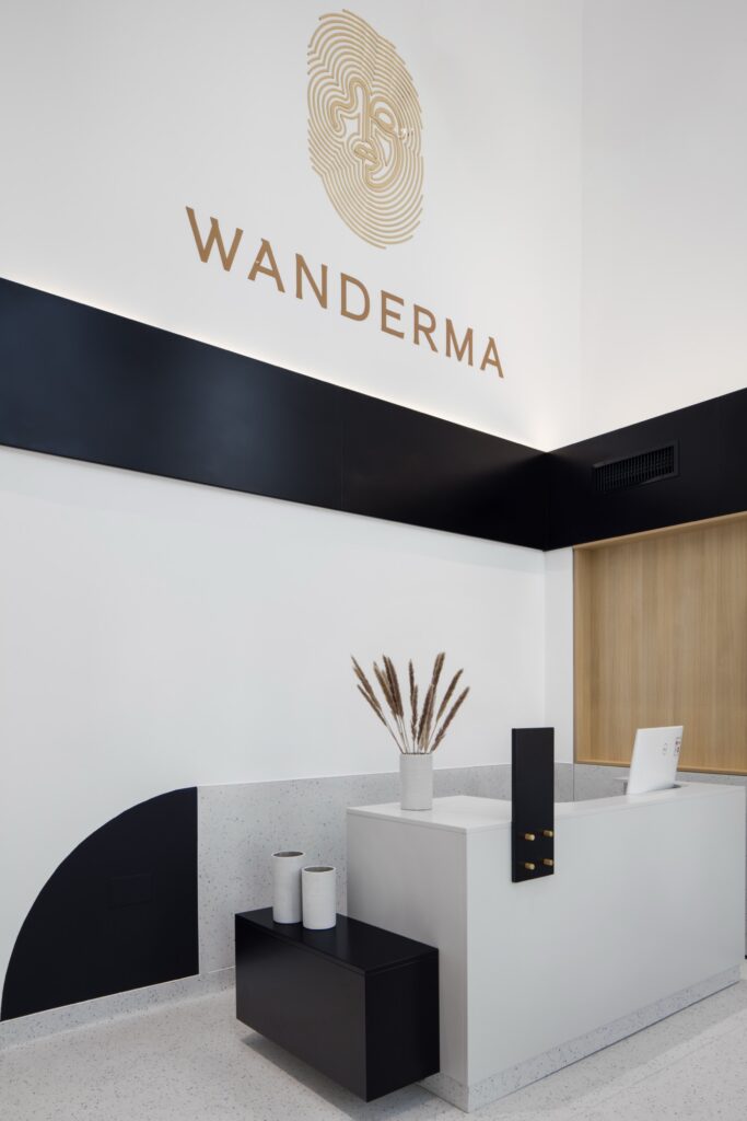 Recepția clinicii Wanderma din Craiova, cu logoul Wanderma pe perete.